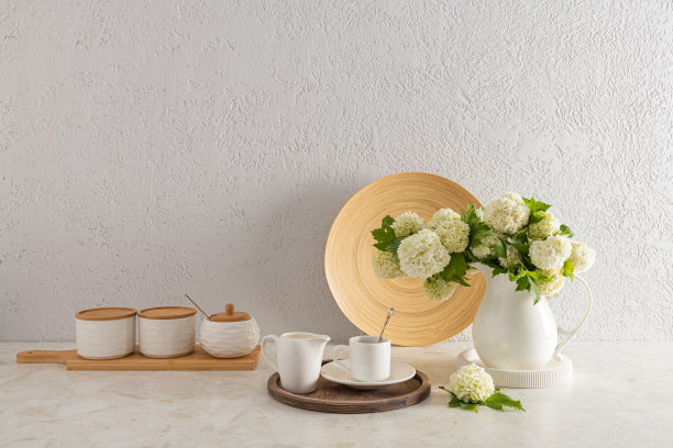 时尚的现代厨房背景与陶瓷储物罐，咖啡杯，陶瓷白色壶与鲜花。一个拷贝空间。图片下载