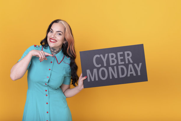 美女指着黄色背景下的“网络星期一”标志图片下载