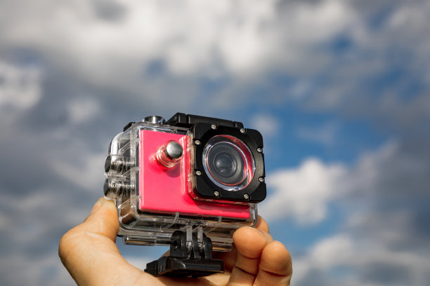 手里拿着装在保护盒里的运动相机。图片下载