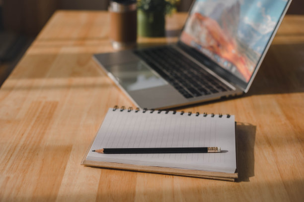 笔记本电脑，咖啡杯，笔记本和室内植物。图片下载