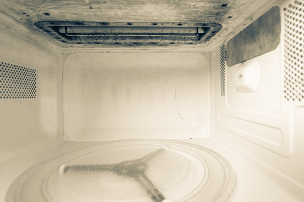 清洁和脏的微波炉前后清洗，特写。厨房用具经过清洗和清洁。图片下载