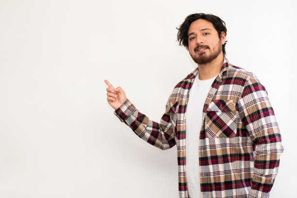 西班牙裔男子的肖像用手指指向左边空白的地方，白色背景的复制空间图片下载
