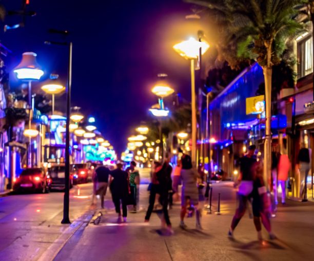 人们在夜晚与汽车和霓虹灯一起行走和穿过街道图片下载