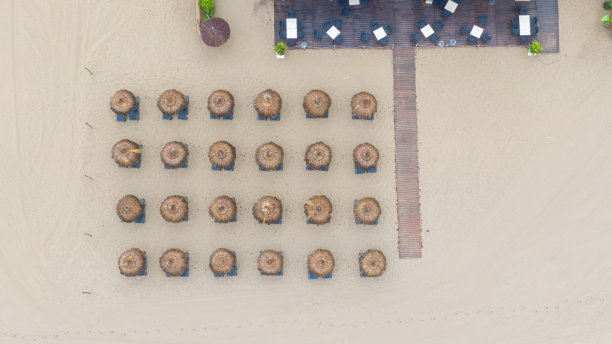 顶着遮阳伞的沙滩，西班牙马贝拉。鸟瞰对称排列的日光浴床图片下载