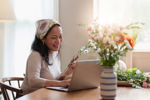 创业，小生意，花店。老花商把花插在花瓶上图片下载