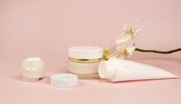 玻璃和塑料罐和蝴蝶兰花在粉红色的背景。面部和身体护理理念。模型。图片下载