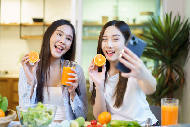 喝橙汁的年轻妇女。图片下载