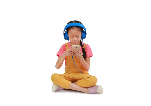 亚洲小女孩戴着耳机，享受着智能手机，独自坐在白色背景上。图像与剪辑路径图片下载
