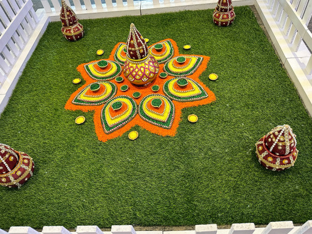 为庆祝排灯节而设计的gulal rangoli特写图片，用彩色粉末颜料在白色尖桩围栏围成的草地上绘制的图案，庆祝节日的灯光，高架视图图片下载
