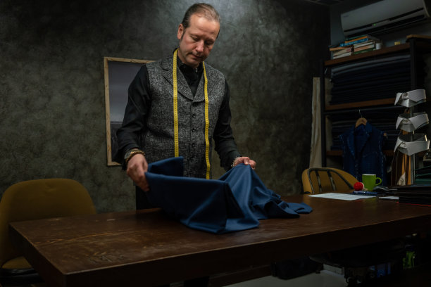 男时装设计师还在向桌垂直时装设计师开布面料图片下载