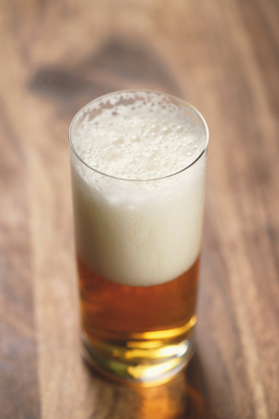 木板上的玻璃杯里装着啤酒图片下载