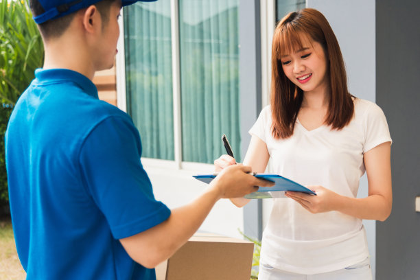 在剪贴板上签名的女士从快递员那里拿到了她的包裹图片下载