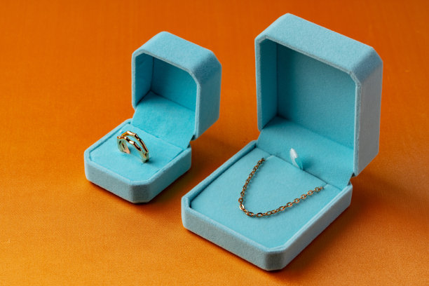 蓝色盒子和金色珠宝在橙色的背景图片下载