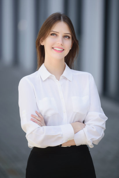 美丽的白人女孩站在街上，双臂交叉图片下载