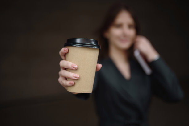 一个女孩手里的纸杯咖啡，上面有文字的地方图片下载