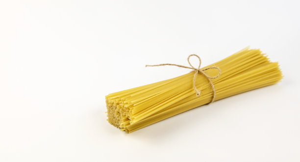 用一根线系在白色背景上的意大利面条。图片下载