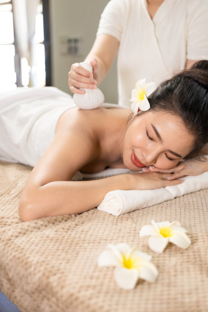 美丽的年轻亚洲妇女在水疗环境按摩，传统的芳香疗法和美容疗法，特写照片。图片下载