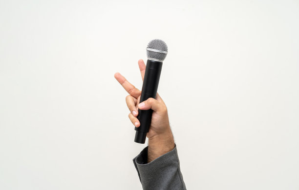 近距离商人扬声器手持高品质的动态麦克风和唱歌或说话与人交谈孤立的白色背景。男性为面试测试麦克风声音图片下载