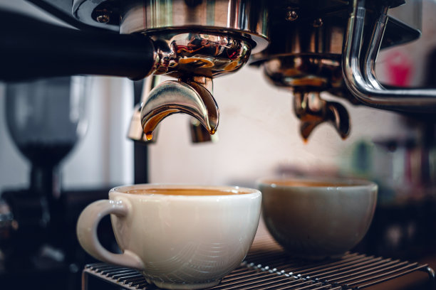 浓缩咖啡从一个专业的咖啡机与无底过滤器提取，特写从咖啡机的咖啡滴图片下载