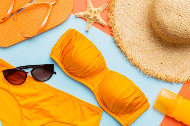 女子泳装和沙滩配饰平铺上视图彩色背景夏季旅游概念。比基尼泳衣，草帽和高跟鞋。复制空间俯视图图片下载