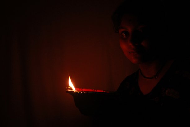 年轻的印度少女手持排灯节粘土油灯图片下载