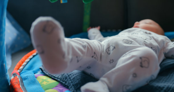 宝宝穿着睡衣在垫子上玩耍，这是为了孩子的成长，或者在客厅里学习。房子，健康和健康与一个可爱的小新生儿室内自然成长图片下载