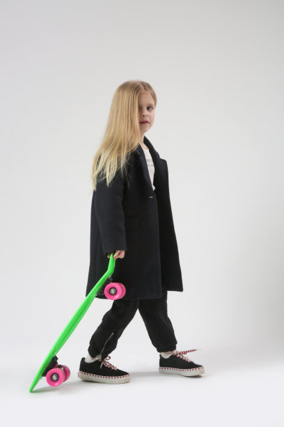 漂亮的金发小女孩的工作室肖像与滑板图片下载