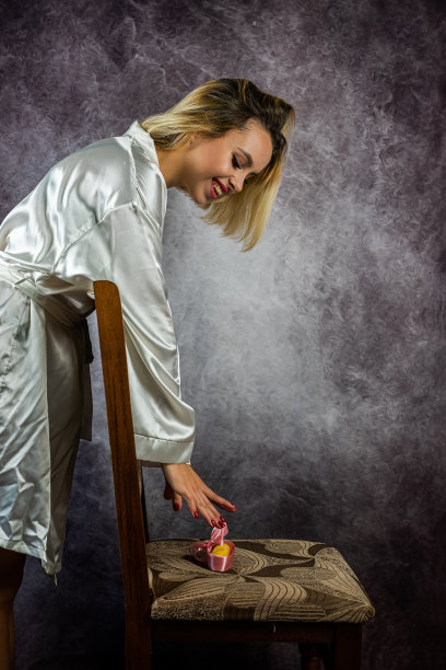 年轻苗条的金发女子，穿着时髦的晨衣，在美丽的背景下孤立起来。图片下载