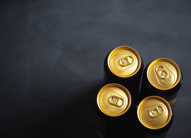 四个啤酒罐在黑色的桌面视图与复制空间图片下载