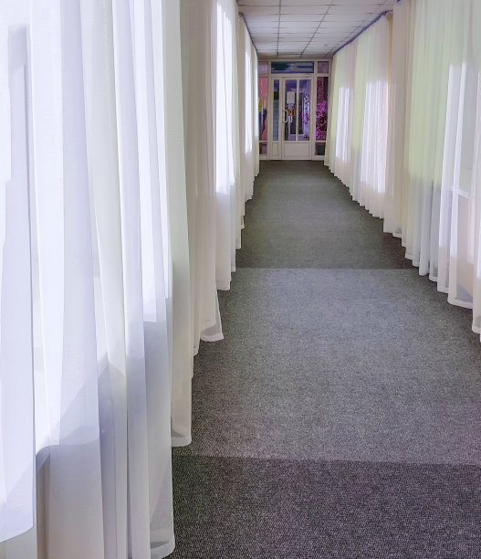 长长的酒店走廊，大窗户和玻璃门上挂着透明的窗帘图片下载