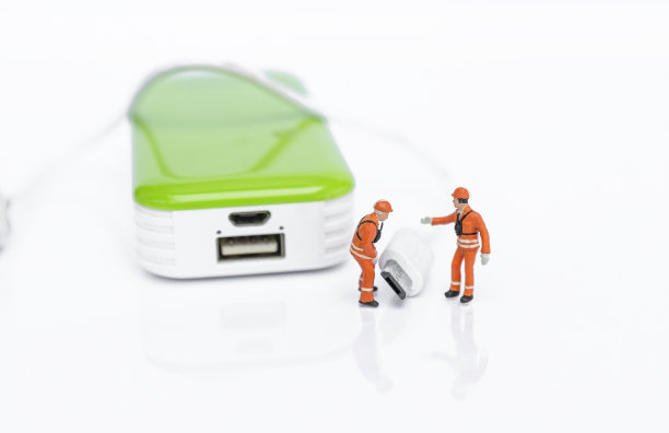 带有USB连接线和移动电源的微型工人在白色背景上隔离图片下载