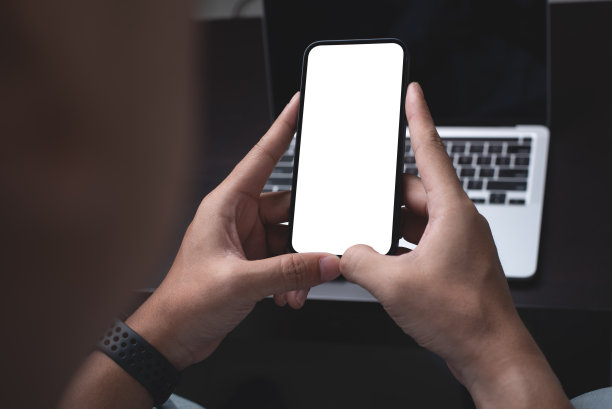 样机，空白屏幕手机。男人在家里办公室的沙发上手拉手玩手机。广告文本的复制空间。业务联系，人沟通。技术装置概念图片下载