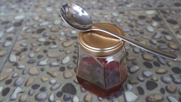 蜂蜜在勺子和玻璃罐中。食品饮料和健康背景图片下载