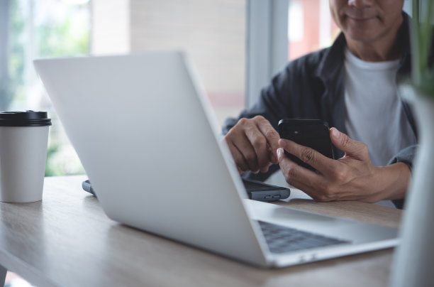 亚洲商务人士穿着智能休闲装，在现代家庭办公室的桌子上用笔记本电脑上网工作图片下载