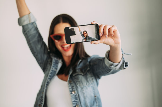 美女用智能手机拍照的特写，自拍。图片下载