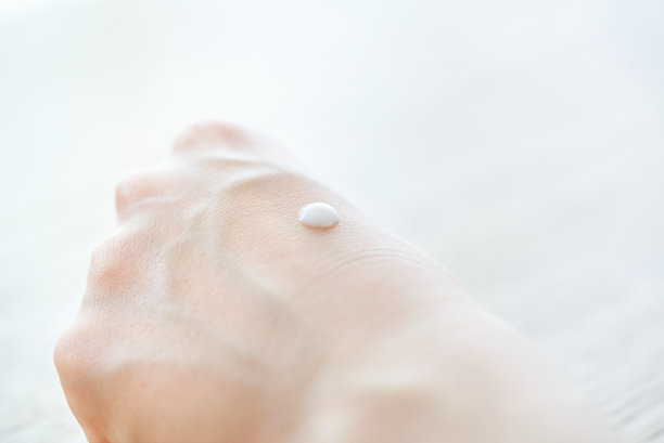 一个在手上涂乳液的女人图片下载