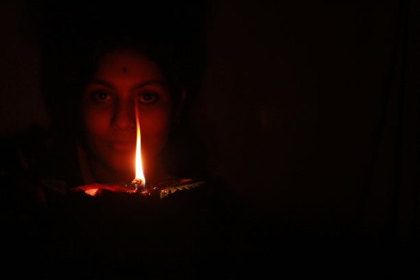 年轻的印度少女手持排灯节粘土油灯图片下载