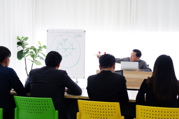 高级亚洲讲师正在谈论商业和股票市场的话题，商务人士正在举行研讨会，对大学会议室里的经济学课知识感兴趣。图片下载
