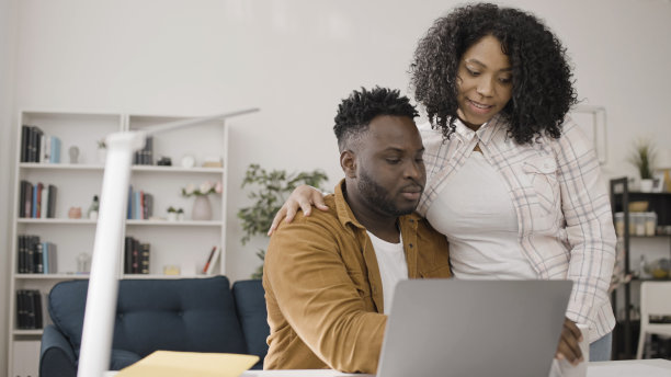 好奇的妻子对丈夫的工作很感兴趣，因为他坐在他的笔记本电脑前工作图片下载