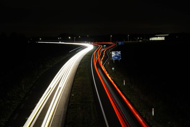 夜间高速公路上汽车灯光轨迹的航拍长曝光视图图片下载