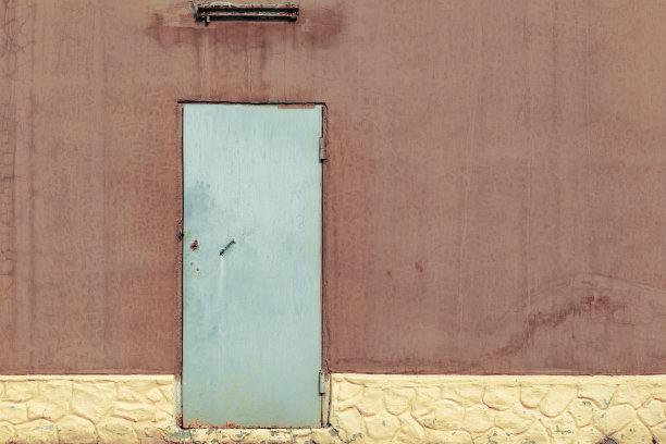 棕色的墙上挂着灰色的金属门。图片下载