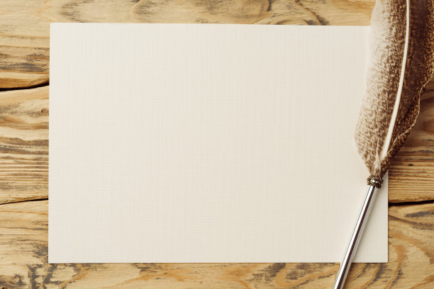 旧纸在棕色的木头背景与羽毛图片下载