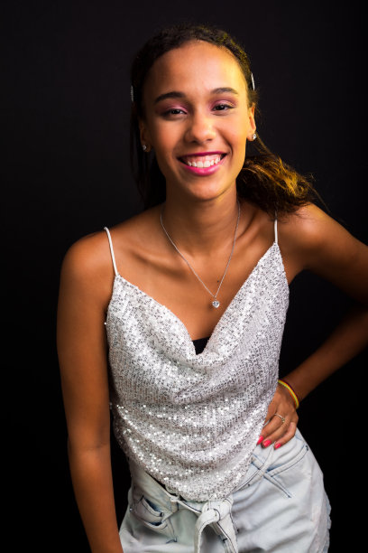 穿着白色衣服的漂亮少女在摄影棚里摆姿势拍照。图片下载