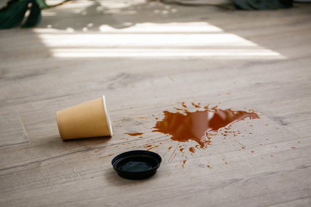 纸杯咖啡掉在地板上，咖啡洒在地板上。图片下载