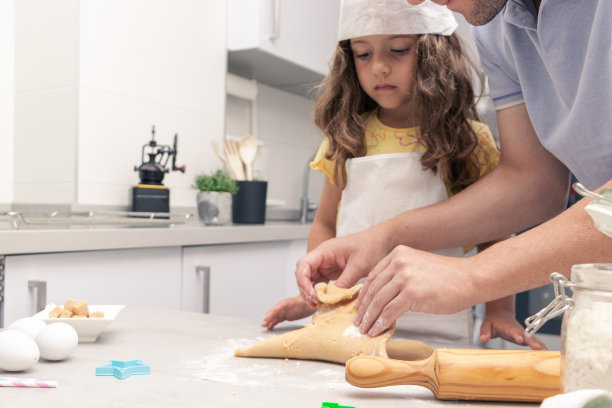 烘焙热情:年轻的面包师快乐地滚动饼干面团图片下载