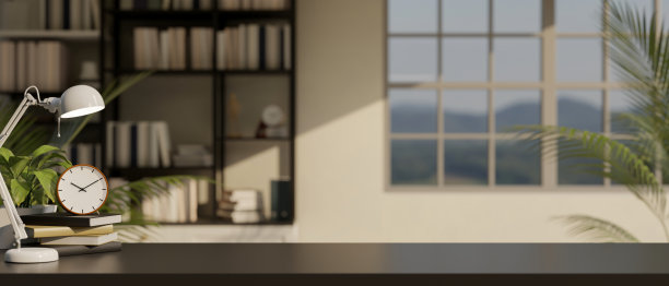 现代的工作空间，复制空间在一个黑暗的桌面上，闹钟，台灯，和书。图片下载