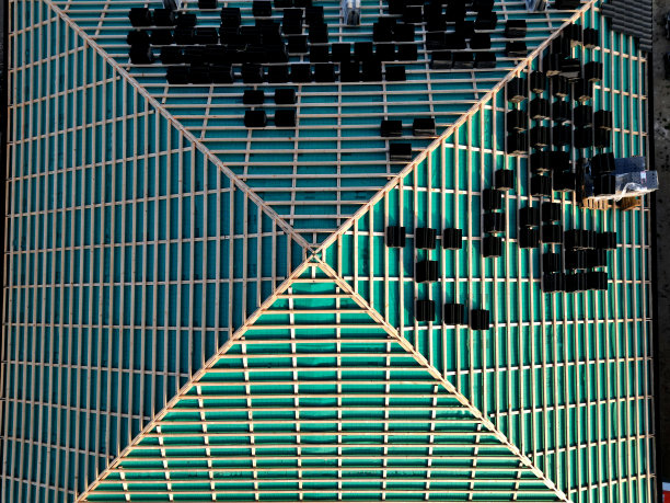 有几个屋顶正在施工的建筑工地。有透气性箔的屋顶。瓦片放在屋顶上。混凝土烟囱穿过。审批质量控制。从上面看图片下载