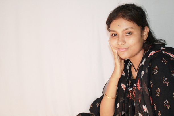 一个十几岁的印度女孩正把手放在脸颊上坐着。图片下载