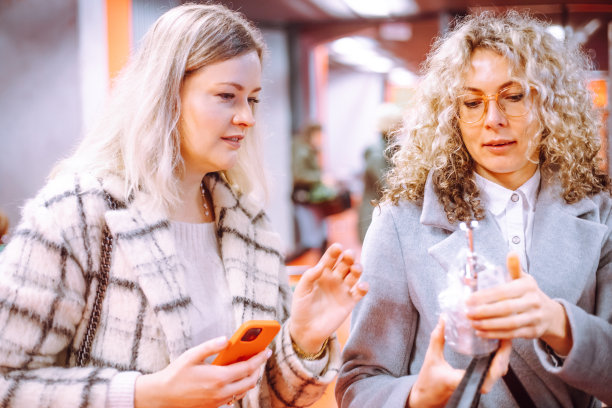 两个女朋友，同事有兴趣考虑在花园中心种植某种植物。大量选择。图片下载