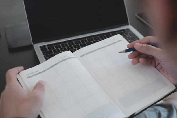 2023日历活动策划时间表议程计划组织日程安排。活动策划日程安排按组织者日程安排。商务人士将笔记放在笔记本上，日历放在办公桌上图片下载